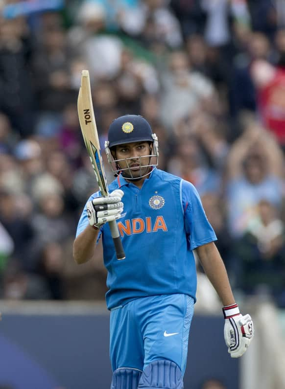 Rohit Sharma holds up his bat to acknowledge reaching 50 runs during the ICC Champions Trophy group B cricket match between India and West Indies at The Oval cricket ground in London.