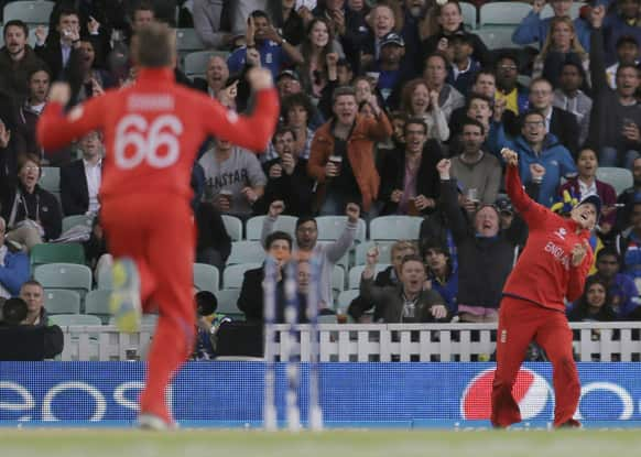 England's bowler Graeme Swann turns and runs towards teammate Joe Root as he celebrates catching out Sri Lanka's Tilakaratne Dilshan during their ICC Champions Trophy cricket match at the Oval cricket ground in London.