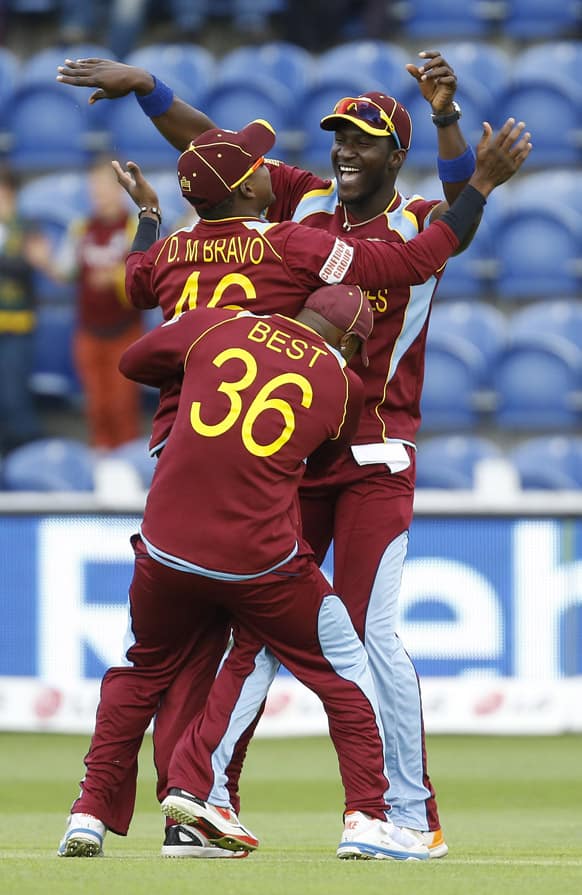 West Indies' Dwayne Bravo, Darren Sammy and Tino Best celebrate taking the wicket of South Africa's AB de Villiers during an ICC Champions Trophy cricket match between West Indies and South Africa at the Cardiff Wales Stadium in Cardiff.