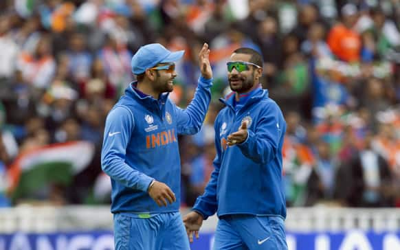 Virat Kohli, left, celebrates with teammate Shikhar Dhawan after running out Pakistan's Junaid Khan for 0 during their ICC Champions Trophy cricket match.