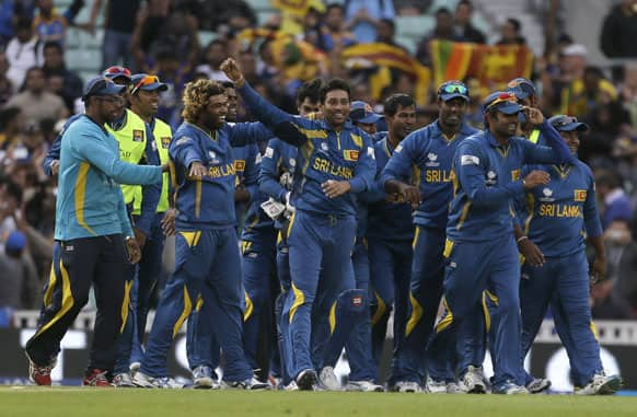 Tilakaratne Dilshan, centre, celebrates with teammates after taking the wicket of Australia's Clint McKay caught and bowled to win their ICC Champions Trophy cricket match at the Oval cricket ground in London.