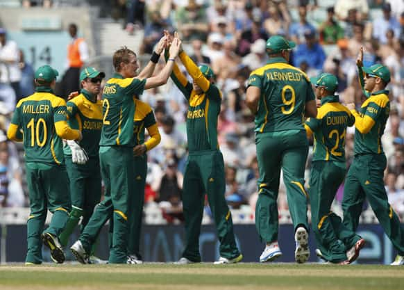 South Africa's Chris Morris, third left, celebrates with teammates the wicket of England's Alastair Cook caught by teammate AB de Villiers during their ICC Champions Trophy semifinal cricket match at the Oval cricket ground in London.