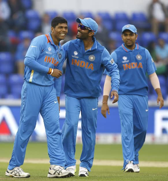 Umesh Yadav, left, and Dinesh Karthik, center, laugh after Yadav is accidentally knocked by the ball during an ICC Champions Trophy semifinal between India and Sri Lanka at the Cardiff Wales Stadium in Cardiff.