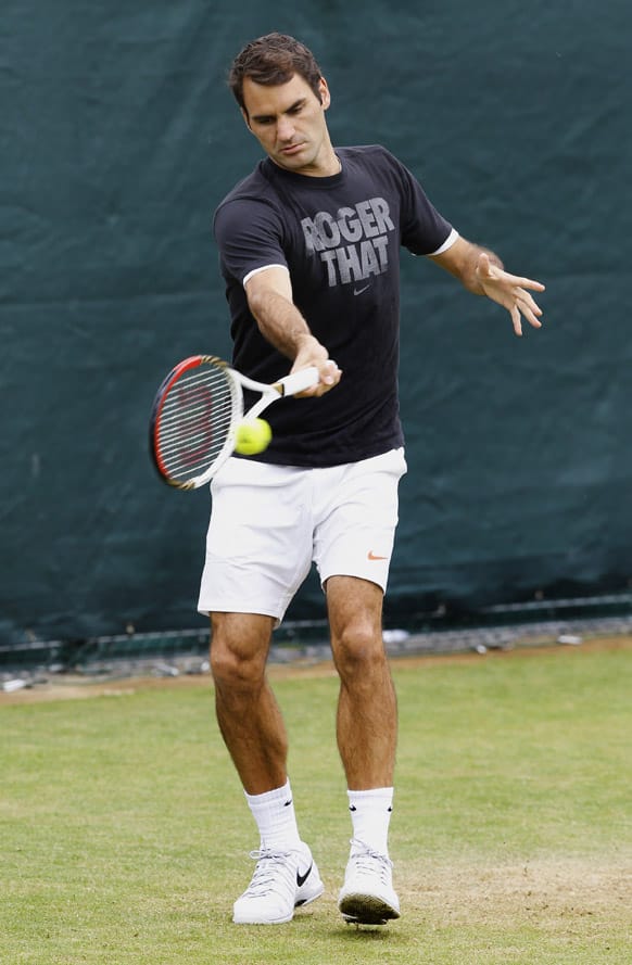 Roger Federer of Switzerland plays a return during a training session at the Wimbledon tennis championships in London.