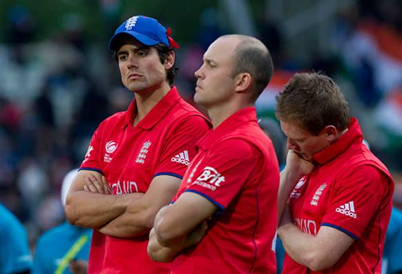 England's captain Alastair Cook, left, stands alongside teammates Jonathan Trott, centre, and Eoin Morgan after their loss to India in their ICC Champions Trophy Final cricket match at Edgbaston cricket ground, Birmingham.