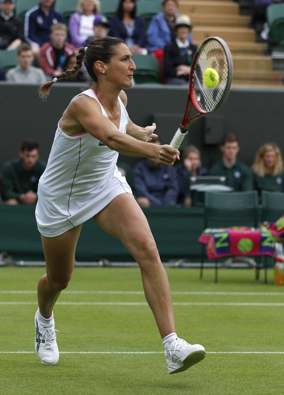 Virginie Razzano of France volleys a return to Ana Ivanovic of Serbia during their Women's first round singles match at the All England Lawn Tennis Championships in Wimbledon.