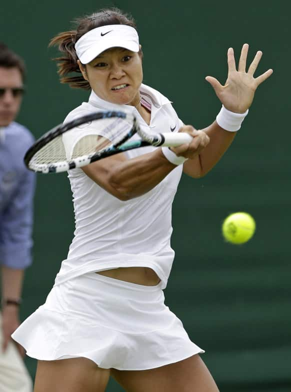 Li Na of China returns the ball to Michaella Krajicek of the Netherlands during a Women's first round singles match at the All England Lawn Tennis Championships in Wimbledon.