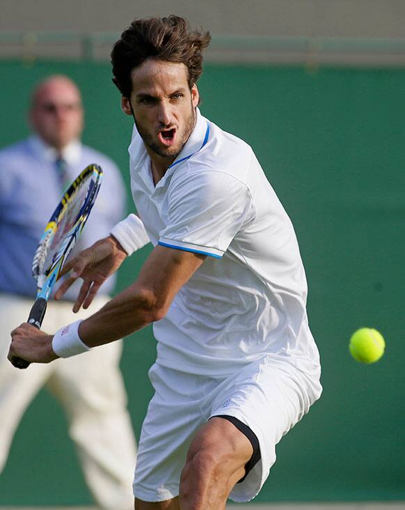 Feliciano Lopez of Spain plays a return to Gilles Simon of France during their Men's first round singles match at the All England Lawn Tennis Championships in Wimbledon.