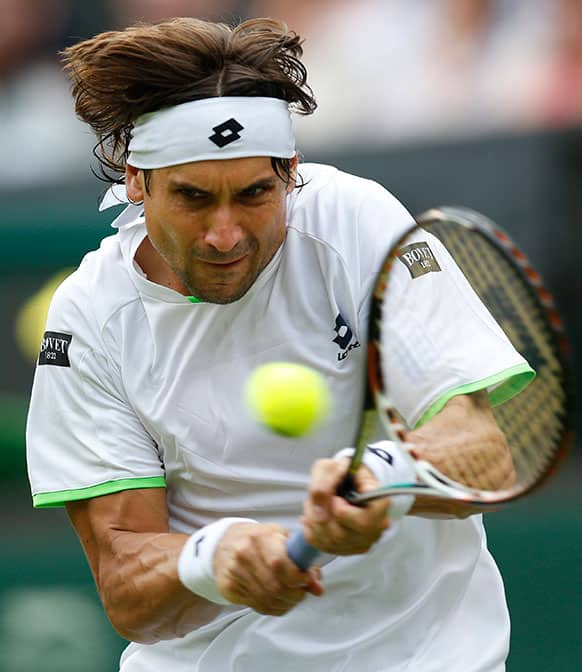 David Ferrer of Spain plays a return to Martin Alund of Argentina during their Men's first round singles match at the All England Lawn Tennis Championships in Wimbledon.