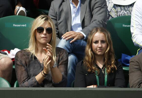 Maria Sharapova of Russia, left, applauds as she watches her boyfriend Grigor Dimitrov of Bulgaria as he plays Grega Zemlja of Slovenia during their Men's second round singles match at the All England Lawn Tennis Championships in Wimbledon.