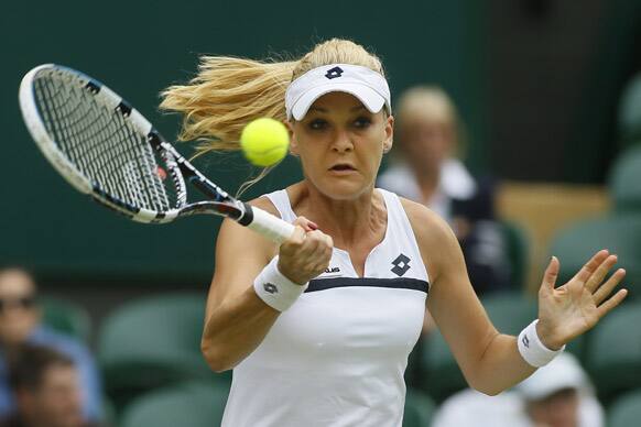 Agnieszka Radwanska of Poland plays a shot to Mathilde Johansson of France during their Women's second round singles match at the All England Lawn Tennis Championships in Wimbledon.