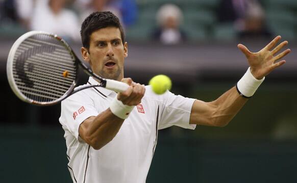 Novak Djokovic of Serbia returns to Bobby Reynolds of the United States during their Men's second round singles match at the All England Lawn Tennis Championships in Wimbledon.