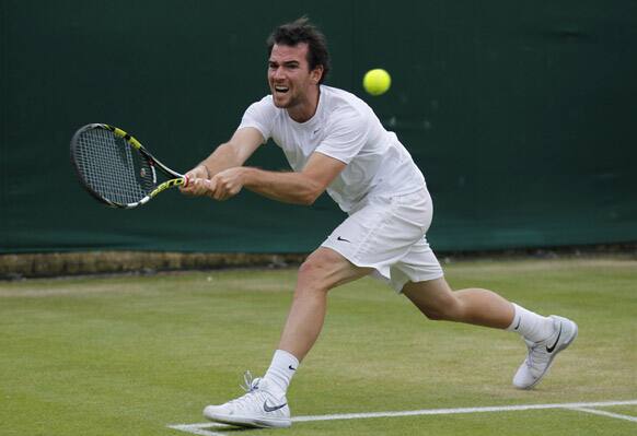 Adrian Mannarino of France plays a return to Dustin Brown of Germany during their Men's singles match against at the All England Lawn Tennis Championships in Wimbledon.