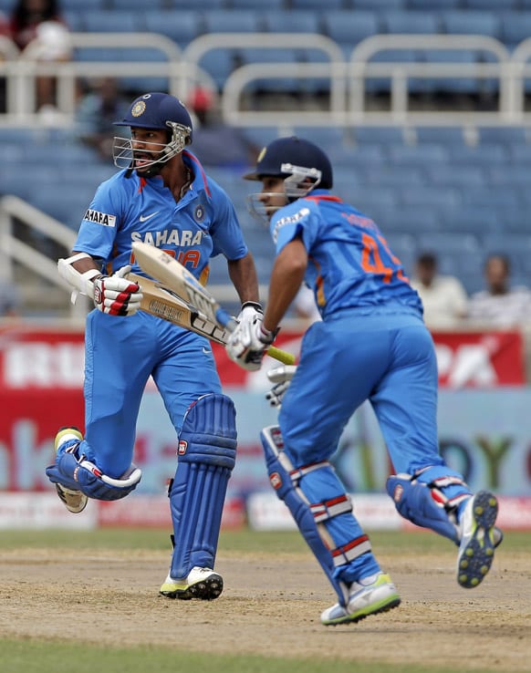 Shikhar Dhawan, left, and Rohit Sharma run between the wickets during the Tri-Nation Series cricket match against West Indies in Kingston, Jamaica.