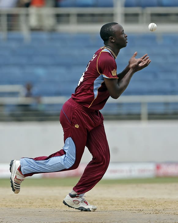 West Indies' bowler Kemar Roach takes the catch to dismiss India's opening batsman Shikhar Dhawan for 11 runs during their Tri-Nation Series cricket match in Kingston, Jamaica.