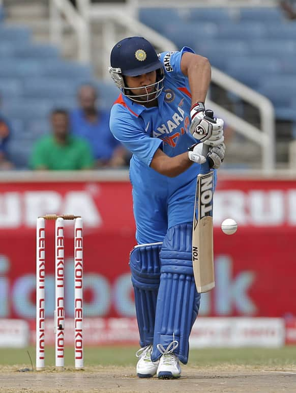 Rohit Sharma drives a delivery off West Indies' Kemar Roach during their Tri-Nation Series cricket match in Kingston, Jamaica.