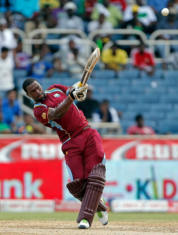 Johnson Charles smashes a six off India's spinner Ravindra Jadeja during their Tri-Nation Series cricket match in Kingston, Jamaica.