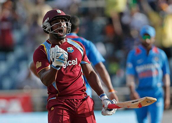 Tino Best celebrates after his batting partner Kemar Roach, unseen, scored the wining run off India's bowler Umesh Yadav during their Tri-Nation Series cricket match in Kingston, Jamaica.