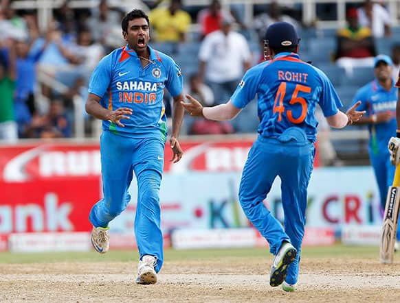 Ravichandran Ashwin, left, celebrates with teammate Rohit Sharma after bowling out West Indies' Denesh Ramdin for four runs during their Tri-Nation Series cricket match in Kingston, Jamaica.