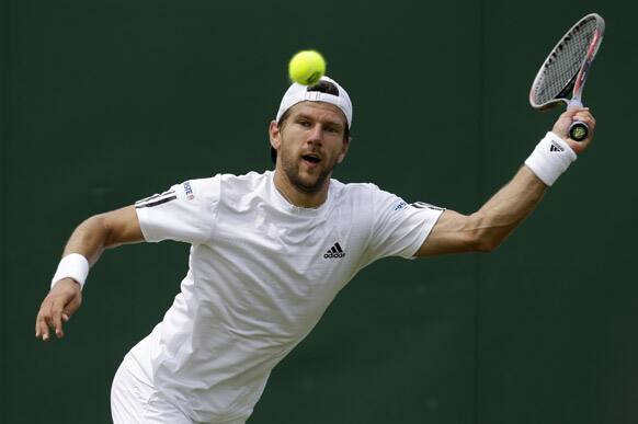 Jurgen Melzer of Austria returns to Jerzy Janowicz of Poland during their Men's singles match at the All England Lawn Tennis Championships in Wimbledon.