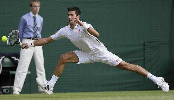 Novak Djokovic of Serbia returns to Tommy Haas of Germany during a Men's singles match at the All England Lawn Tennis Championships in Wimbledon, London.