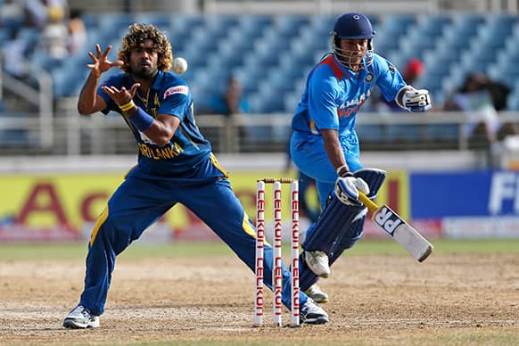 India's Umesh Yadav, right, avoids being run out by Sri Lanka's Lasith Malinga during their Tri-Nation Series cricket match in Kingston, Jamaica.