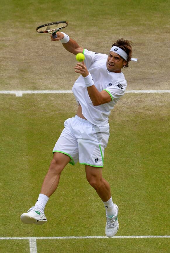 David Ferrer of Spain plays a return to Juan Martin Del Potro of Argentina during their Men's singles quarterfinal match at the All England Lawn Tennis Championships in Wimbledon, London.