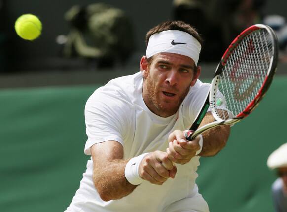 Juan Martin Del Potro of Argentina returns to Novak Djokovic of Serbia during their Men's singles semifinal match at the All England Lawn Tennis Championships in Wimbledon.