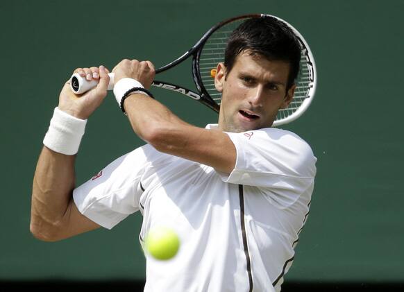 Novak Djokovic of Serbia returns to Juan Martin Del Potro of Argentina during the Men's singles semifinal match at the All England Lawn Tennis Championships in Wimbledon.