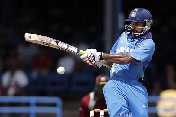 Shikhar Dhawan drives a delivery off West Indies' Kemar Roach during their Tri-Nation Series cricket match in Port-of-Spain, Trinidad.