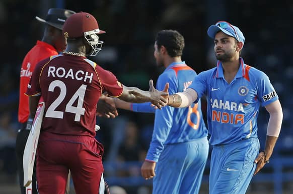 Virat Kohli, right, shakes hands with West Indies' Kemar Roach at the end of their Tri-Nation Series cricket match in Port-of-Spain, Trinidad.