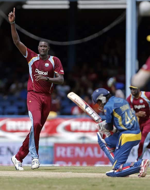 West Indies bowler Jason Holder, left, celebrates after taking the wicket of Sri Lanka opening batsman Upul Tharanga, right, who was caught by teammate Darren Bravo for 7 runs, during their Tri-Nation Series cricket match in Port-of-Spain.