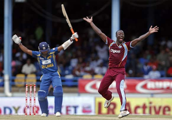 West Indies' Kemar Roach, right, appeals unsuccessfully for the catch behind of Sri Lanka batsman Dinesh Chandimal, left, during their Tri-Nation Series cricket match in Port-of-Spain, Trinidad.