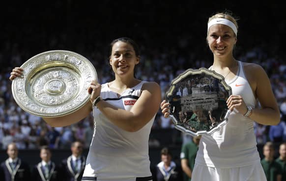 Marion Bartoli of France, left, holds her winners trophy as she stands alongside Sabine Lisicki of Germany during the trophy ceremony after the Women's singles final match at the All England Lawn Tennis Championships in Wimbledon, London.