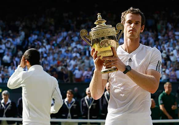 Andy Murray of Britain poses with the trophy after defeating Novak Djokovic of Serbia during the Men's singles final match at the All England Lawn Tennis Championships in Wimbledon.