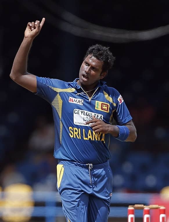 Sri Lanka captain Angelo Mathews celebrates after taking the wicket of India opening batsman Shikhar Dhawan, who was caught by teammate Mahela Jayawardene for 15 runs, during their Tri-Nation Series cricket match in Port-of-Spain.