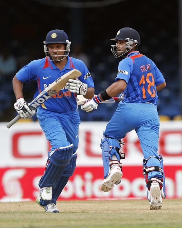 Virat Kohli, right, and Rohit Sharma run between the wickets during the Tri-Nation Series cricket match against Sri Lanka in Port-of-Spain, Trinidad.