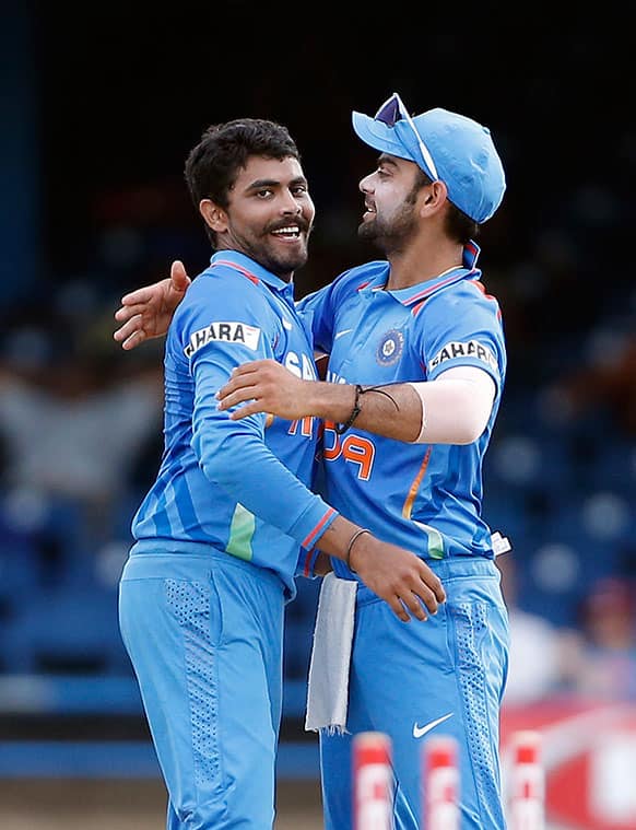 India's Ravindra Jadeja, left, is congratulated by acting captain Virat Kohli for taking the wicket of Sri Lanka's Dinesh Chandimal during their Tri-Nation Series cricket match in Port-of-Spain, Trinidad.