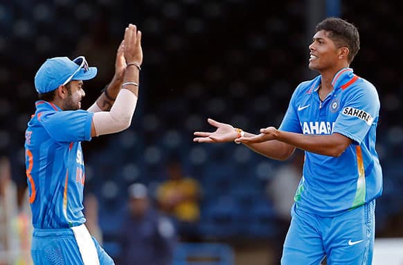 India's acting captain Virat Kohli, left, congratulates bowler Umesh Yadav after he took the wicket of Sri Lanka's Lasith Malinga during their Tri-Nation Series cricket match in Port-of-Spain, Trinidad.