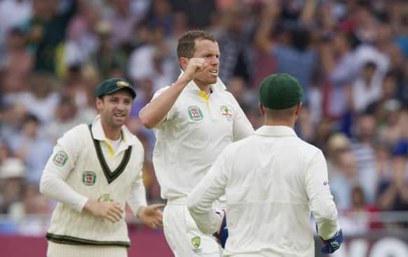 Australia's Peter Siddle celebrates with teammates after bowling England's Joe Root for 30 on the first day of the opening Ashes series cricket match against at Trent Bridge cricket ground, Nottingham, England.