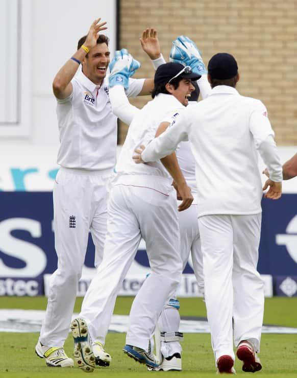 England Steven Finn celebrates with teammates after taking the wicket of Australia's Ed Cowan for 0 caught by Graeme Swann on the first day of the opening Ashes series cricket match at Trent Bridge cricket ground, Nottingham, England.