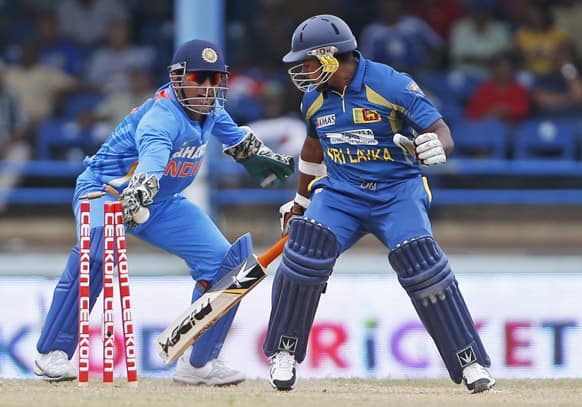 Sri Lanka's Rangana Herath, right, is stumped by India wicket keeper Mahendra Singh Dhoni during the final match of the Tri-Nation cricket series in Port-of-Spain.