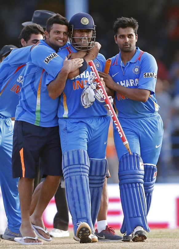 Mahendra Singh Dhoni, center, is hugged by teammates Suresh Raina, left, and Vinay Kumar after their team beat Sri Lanka by one wicke in the final match of the Tri-Nation cricket series in Port-of-Spain, Trinidad.