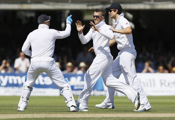 England's Graeme Swann, centre, Alastair Cook, right, and Matt Prior celebrate the wicket of Australia's Steven Smith during day two of the second Ashes Test match held at Lord's cricket ground in London.