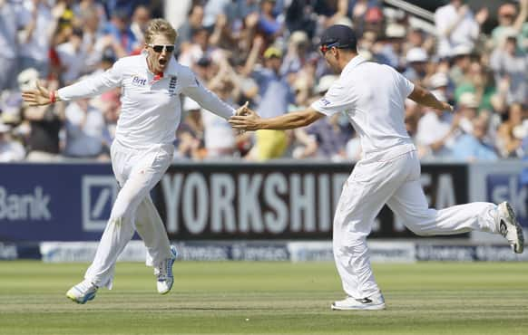 England's Joe Root, left, and Jonathan Trott celebrate the wicket of Australia's captain Michael Clarke during day four of the second Ashes Test match held at Lord's cricket ground in London.