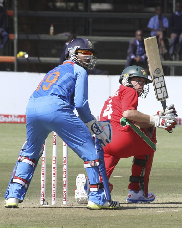 Zimbabwean batsman Sean Williams plays a shot while Indian wicketkeeper Dinesh Karthik looks on, during the one day international cricket match against India in Harare.