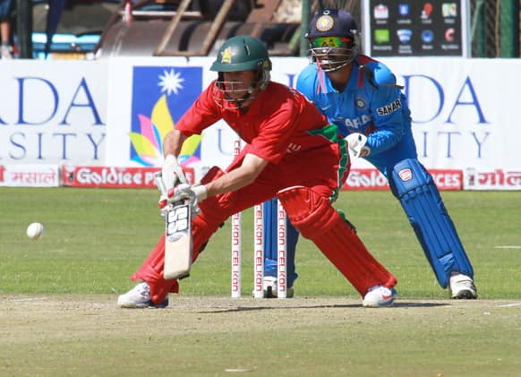 Zimbabwean batsman Sean Williams left, plays a shot as Indian wicketkeeper Dinesh Karthik looks on, during their third one-day international cricket match in Harare.