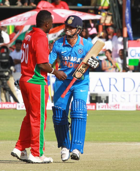 Suresh Raina, right and Zimbabwean bowler Brian Vitori chat during their third one-day international cricket match, in Harare