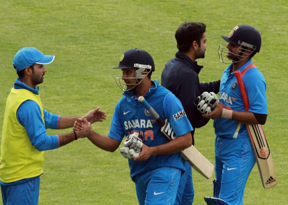 Indian batsman Rohit Sharma, centre and Suresh Raina, right, react with teammates after beating Zimbabwe by 9 wickets during their fourth, one day international match, at Queens Sports Club, in Bulawayo, Zimbabwe.