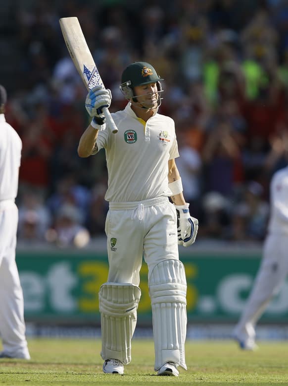 Australia's Michael Clarke holds up his bat after getting his century during day one of the third Ashes Test match held at Old Trafford cricket ground in Manchester, England.